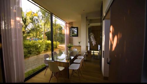 a dining room with a table and white chairs at Tana Palm Madagascar in Antananarivo