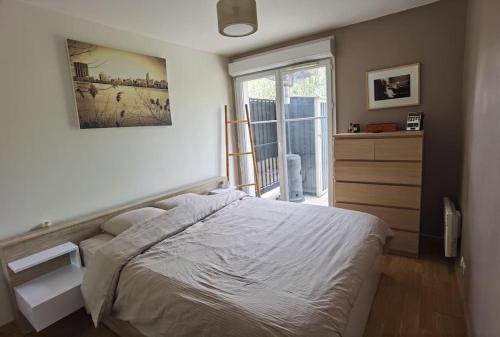 une chambre avec un grand lit et une fenêtre dans l'établissement Appartement avec terrasse proche gare RER, à Moissy-Cramayel