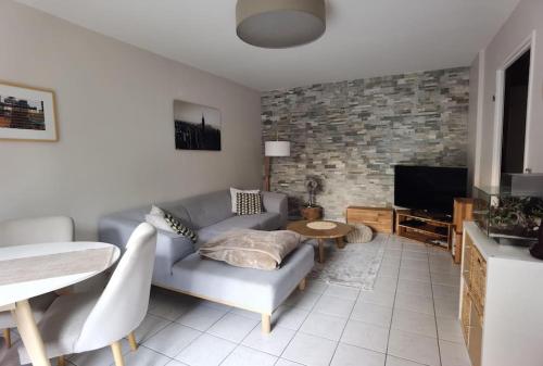 un salon avec un canapé et une télévision dans l'établissement Appartement avec terrasse proche gare RER, à Moissy-Cramayel