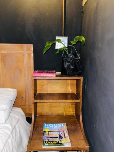 Un dormitorio con una mesa con un libro y una planta. en Cave79, en Gaborone
