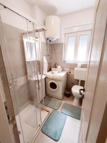 a small bathroom with a toilet and a shower at Apartment "Central Sun" with Balcony and Park View in Knin