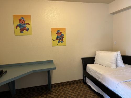 a room with a bed and two pictures on the wall at Travelodge by Wyndham Drumheller AB in Drumheller