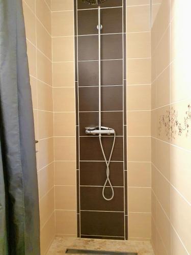 une douche avec un tuyau dans une salle de bain dans l'établissement Les Fargesias, à Saint-Marcel