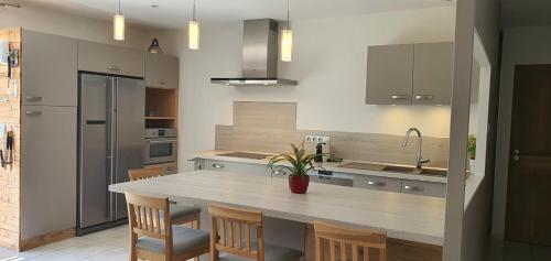 - une cuisine avec une table, des chaises et un évier dans l'établissement Les Fargesias, à Saint-Marcel