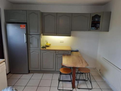 a kitchen with a wooden table and a refrigerator at Fantastic North Coast home in Portstewart