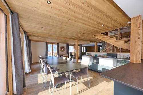 une cuisine et une salle à manger avec une table et des chaises dans l'établissement Chalet les Niverolles PARADISKI, à Peisey-Nancroix