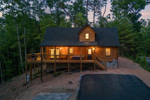 a log cabin in the woods with lights on at Bear's Hideaway in Sevierville