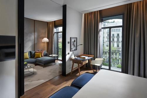バルセロナにあるMandarin Oriental, Barcelonaのベッド1台とリビングルームが備わる客室です。
