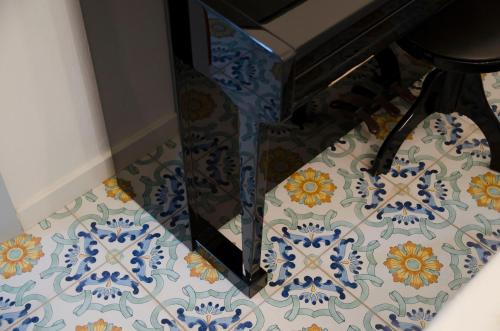 a room with a blue and white tile floor with a stool at Tancredi's Seaside Home in Granelli