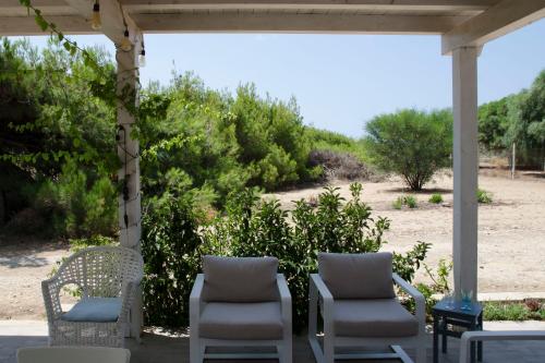 a group of chairs sitting on a porch at Tancredi's Seaside Home in Granelli