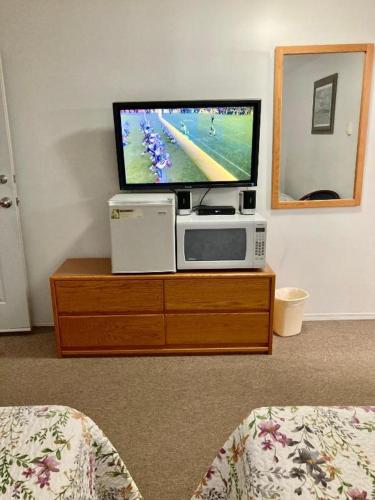 a flat screen tv sitting on top of a wooden dresser at Motel 99 in Grand Forks