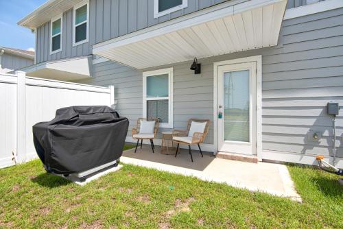 a patio with two chairs and a table in front of a house at Cross Breeze-Gulf Brz-Navarre, Beaches, Boat Ramp in Gulf Breeze