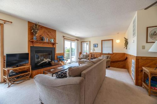 a living room with a couch and a fireplace at Persimmon in Duck