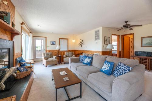 a living room with a couch and a fireplace at Persimmon in Duck