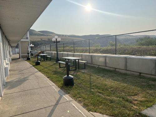 a balcony with picnic tables and a view of the mountains at Travelodge by Wyndham Drumheller AB in Drumheller