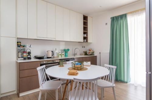 a kitchen with a white table and white chairs at My Nafpaktos Resort in Nafpaktos
