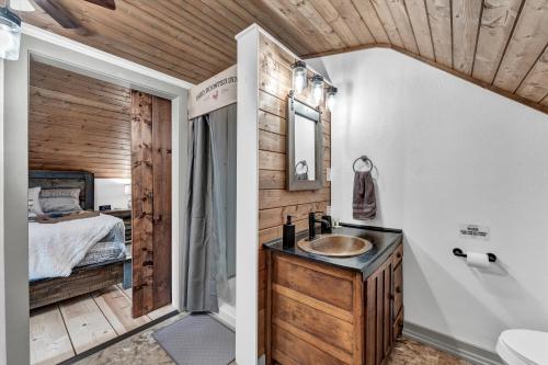 a bathroom with a sink and a bedroom at Rustic Barn Retreat in Knoxville