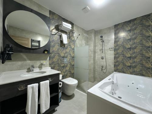 Un baño con lavabo, inodoro y espejo. en KORKMAZ OTEL, en Merzifon