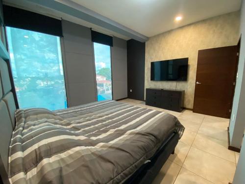 a bedroom with a large bed and a television at Amplio departamento lujoso 3B in Tampico