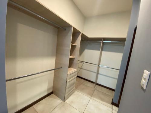 a walk in closet with glass doors and shelves at Amplio departamento lujoso 3B in Tampico