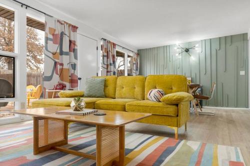 a living room with a yellow couch and a coffee table at Tulsa Funk House in Tulsa