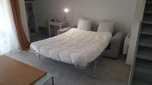 Ce lit se trouve dans un dortoir doté d'une couette blanche. dans l'établissement Chambres chez l'habitant Maison Campagne, à Castelnau-sur-Gupie