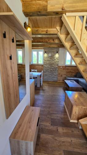 a large room with wooden floors and wooden stairs at Apartmani Cvijeta in Žabljak