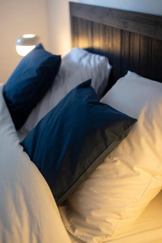 a bed with blue and white pillows and a lamp at Au petit mouton in Fernelmont