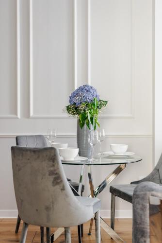 una mesa de comedor con un jarrón de flores y sillas en CISZA i SPOKÓJ, en Raszyn