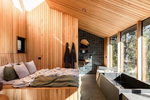 a bedroom with a bed and a bath tub at Hunter Huon Valley Cabin One in Glen Huon