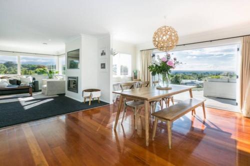a dining room with a table and a living room at Views, close to town in Havelock North
