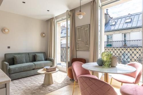 un salon avec un canapé, une table et des chaises dans l'établissement Quartier Libre Marais, à Paris