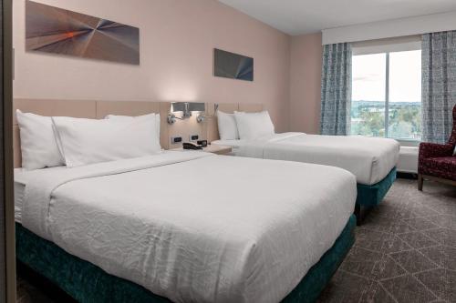 Una habitación de hotel con dos camas y una ventana. en Hilton Garden Inn Colorado Springs Downtown, Co, en Colorado Springs
