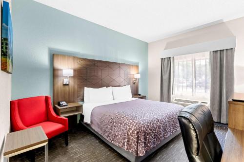 ダルースにあるBest Western Gwinnett Centerのベッドと赤い椅子があるホテルの部屋