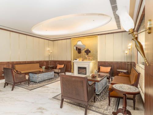 a lobby with a fireplace and tables and chairs at Radisson Collection Hotel & Spa, Riverfront Srinagar in Srinagar