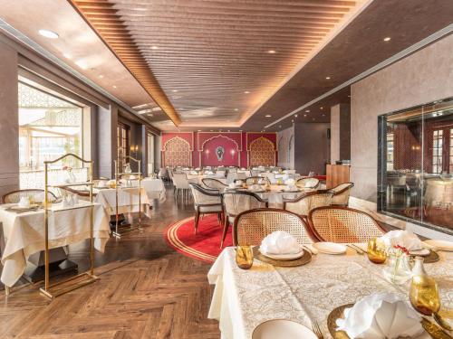 a restaurant with tables and chairs in a room at Radisson Collection Hotel & Spa, Riverfront Srinagar in Srinagar