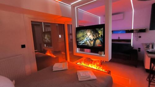 een woonkamer met een tv en een open haard bij Larisa Absolute Suites, Sky View Smart Home in Larisa
