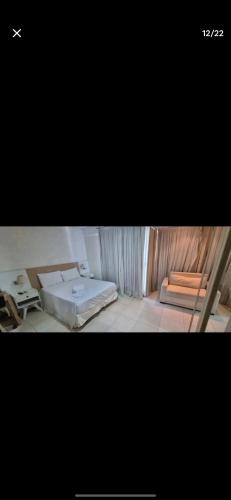 a room with two beds and a table in it at Flat Hotel Saint Moritz ap 2008 in Brasilia