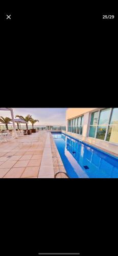 a picture of a swimming pool next to a building at Flat Hotel Saint Moritz ap 2008 in Brasilia
