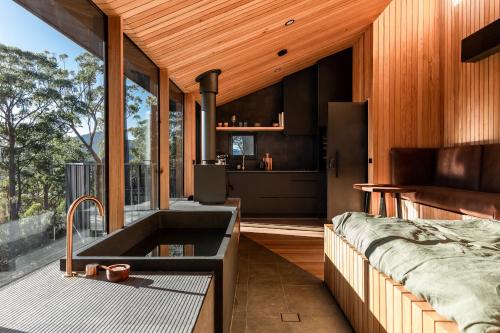 a kitchen with a sink and a bed in a room at Hunter Huon Valley Cabin Three in Glen Huon