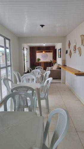 ein Esszimmer mit weißen Tischen und weißen Stühlen in der Unterkunft Pousada Mar de Sonhos in Maragogi
