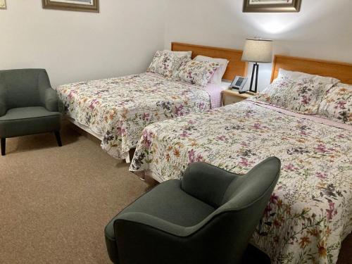 a hotel room with two beds and a chair at Motel 99 in Grand Forks