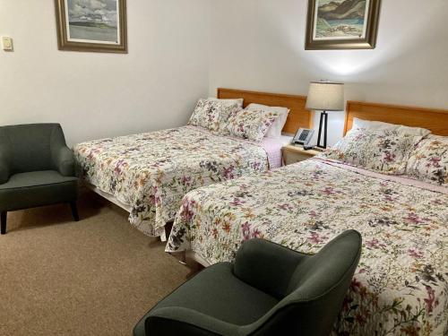 a hotel room with two beds and a chair at Motel 99 in Grand Forks