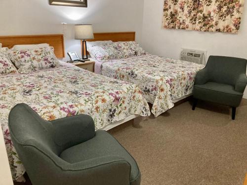 a hotel room with two beds and a chair at Motel 99 in Grand Forks