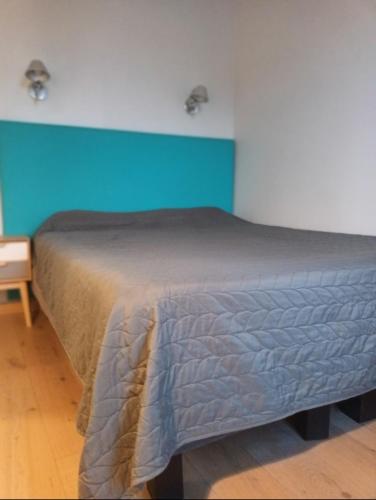 un lit dans une chambre avec un mur bleu dans l'établissement Hôtel de Lorraine, à Paris