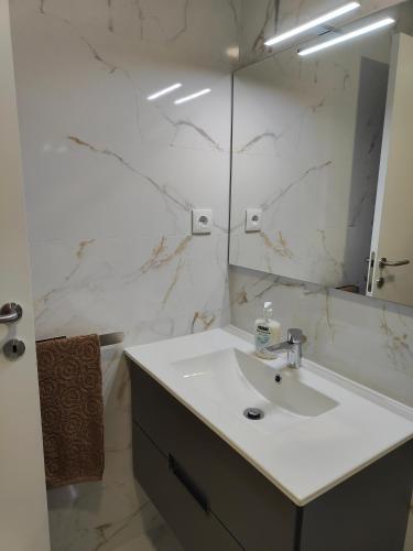 a white bathroom with a sink and a mirror at Loreto House in Bragança