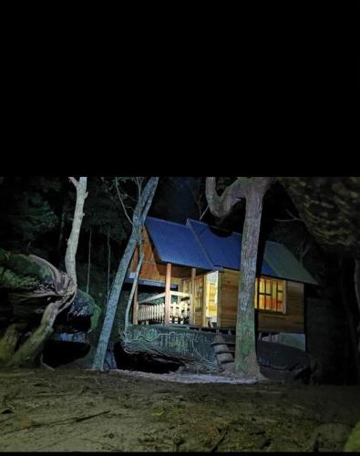 a large log cabin in the woods at night at Piedra Alta in San José del Guaviare