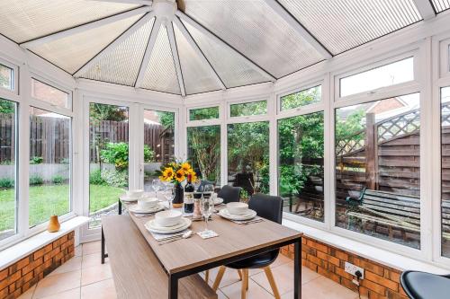 a dining room with a table and chairs and windows at NEW! Stunning 3-Bed Home in Chester by 53 Degrees Property, Ideal for Groups, FREE Parking! in Chester