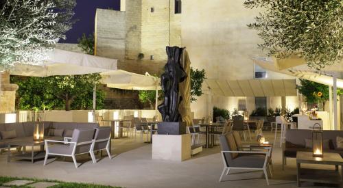 un ristorante con tavoli, sedie e ombrelloni di La Fiermontina Luxury Home Hotel a Lecce