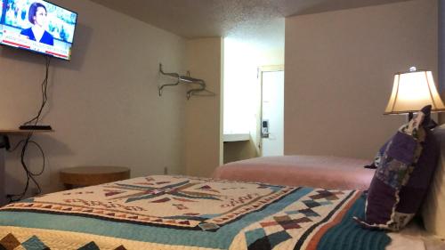 a bedroom with a bed and a tv on the wall at Lake Country Inn in Riverside